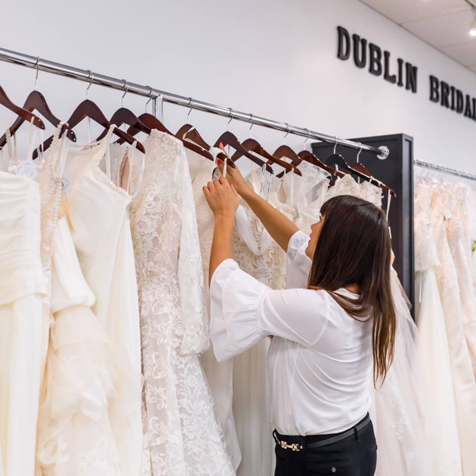 Stylist adjusting wedding dresses on the rack