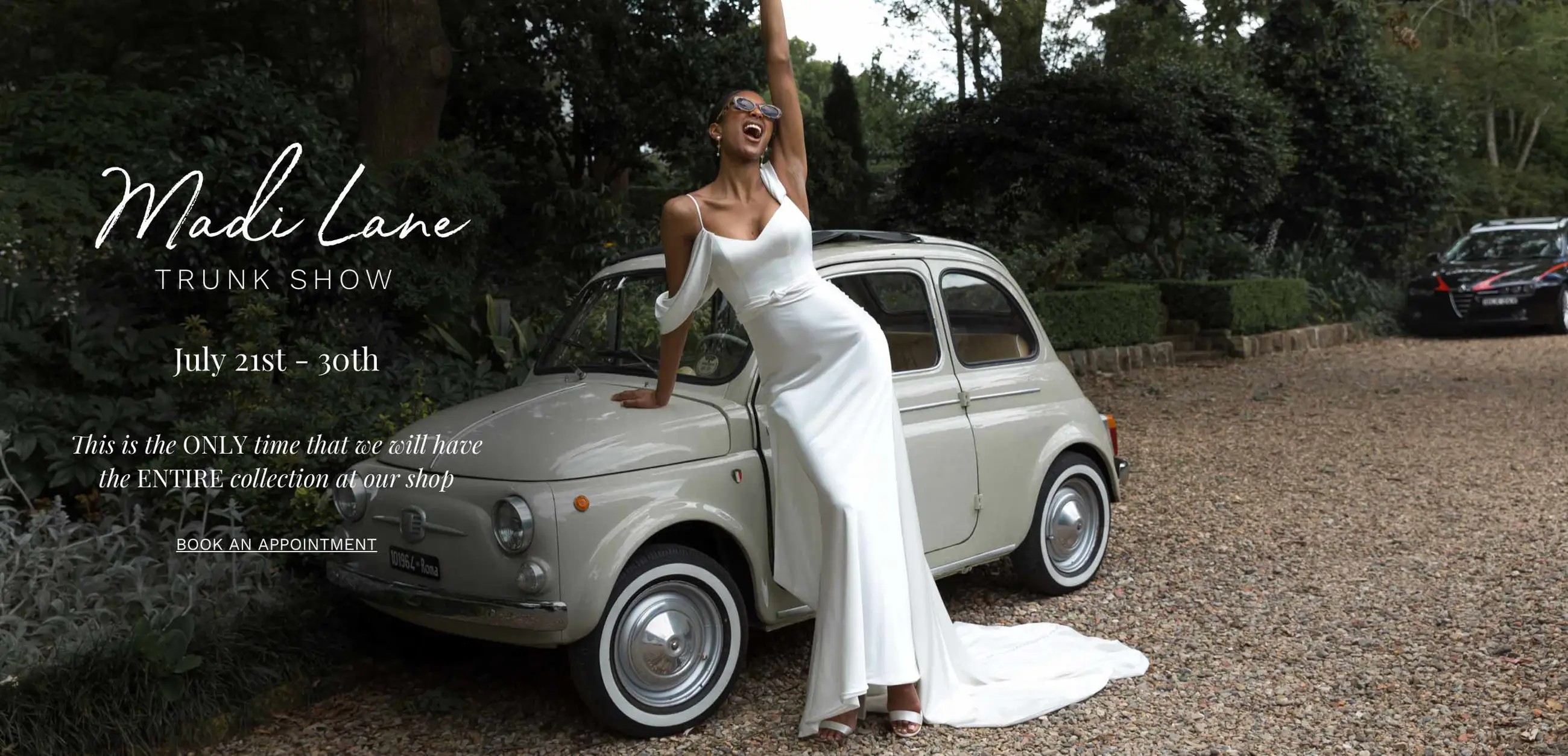 Madi Lane trunk show at Dublin Bridal. Model wearing Madi Lane wedding dresses leaning against vintage car.